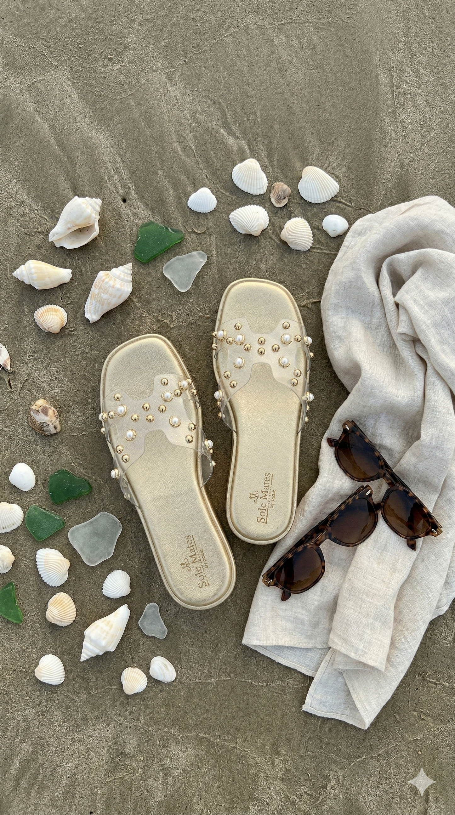 Gold Mist clear strap flatform sliders flat lay with seashells and sunglasses on sand — Solemates by Palak