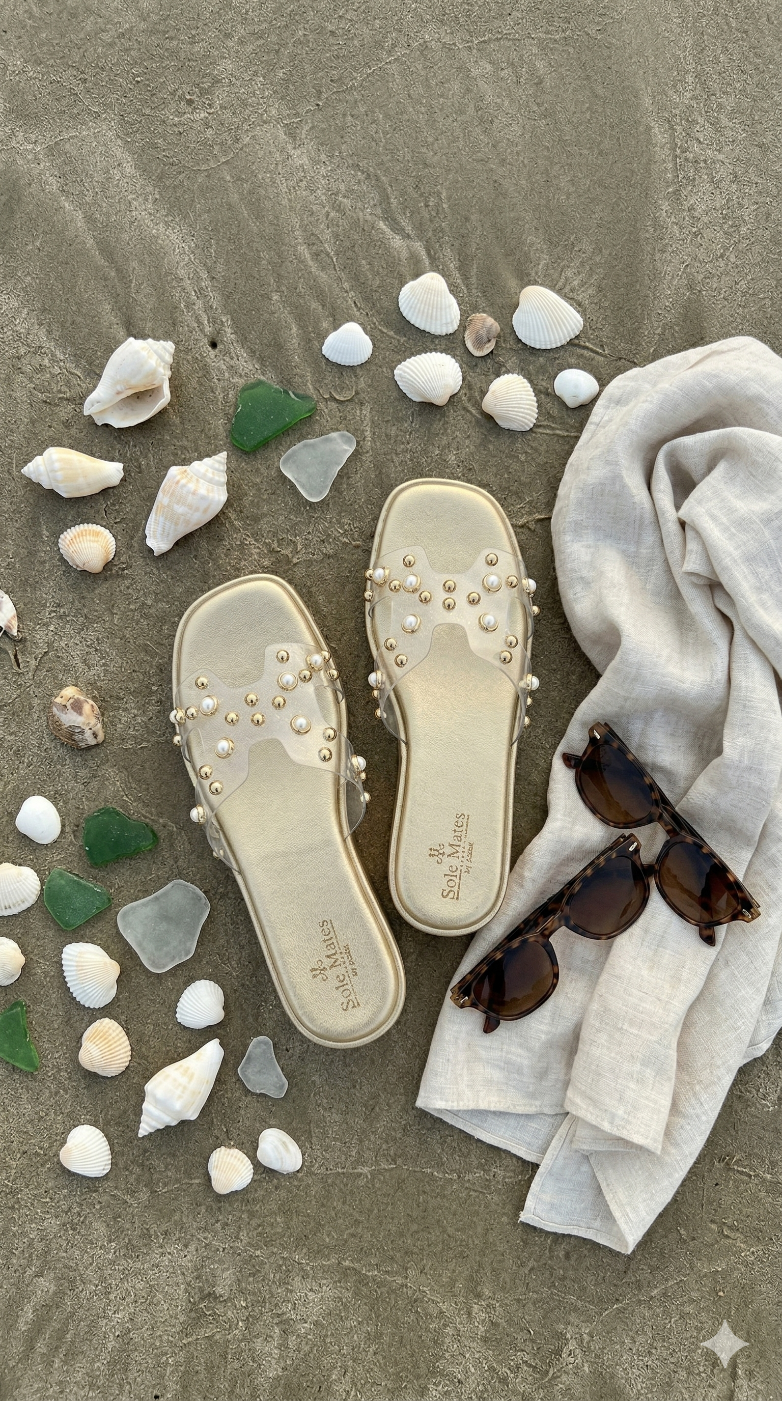 Gold Mist clear strap flatform sliders flat lay with seashells and sunglasses on sand — Solemates by Palak
