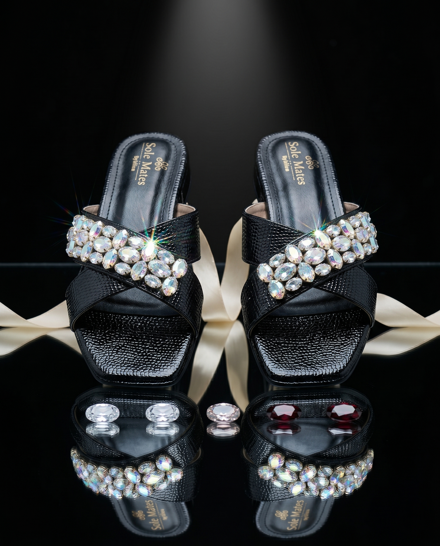 Charolette Black Sliders pair on black mirror surface — black criss-cross patent sliders with large AB crystal and rhinestone cluster by Solemates by Palak
